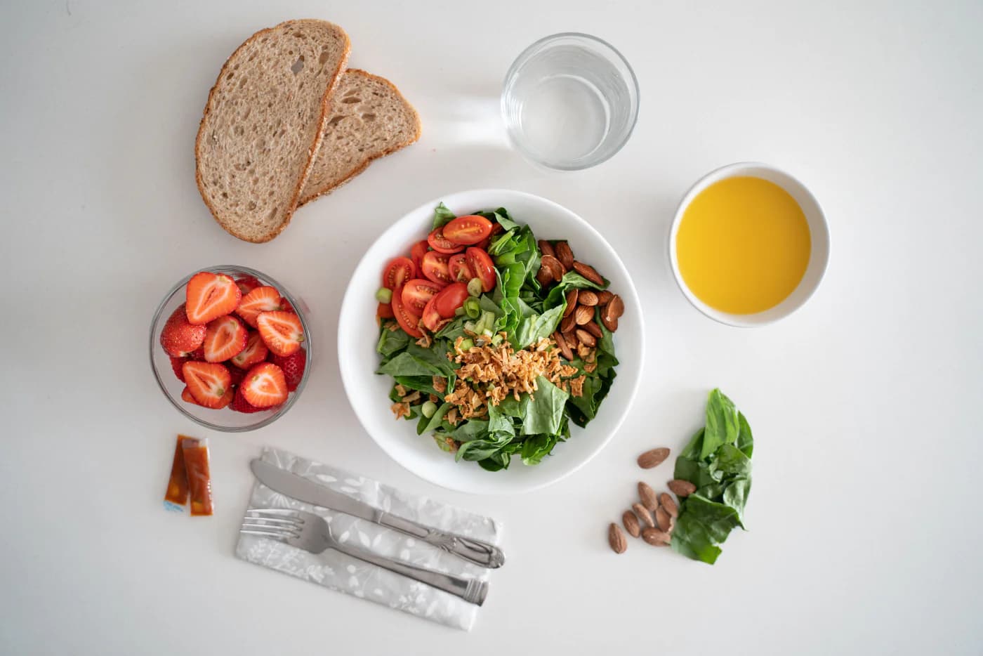 Meal plan laid out flat - salad bowl, fruit, bread and juice