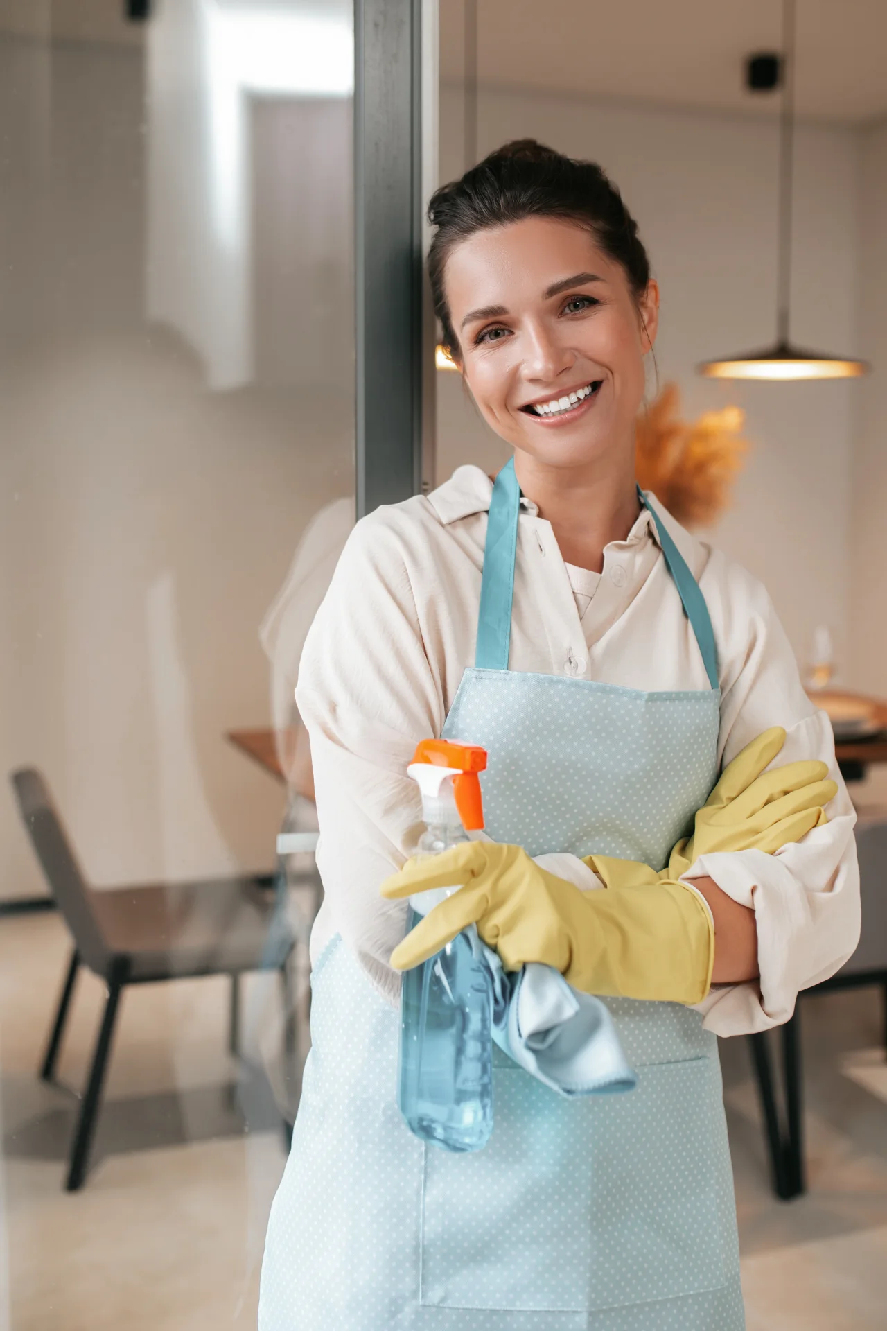 Professional cleaner with a duster and spray bottle